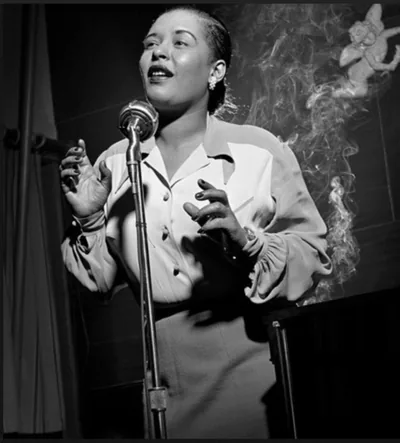 A woman in a white blouse singing into a vintage microphone, smoke curling past a carved cherub