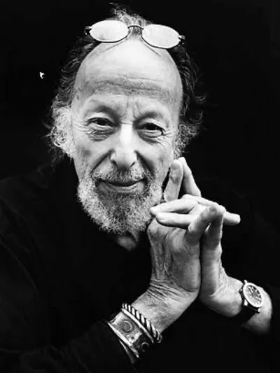 A bearded man resting his chin on his hand, black and white